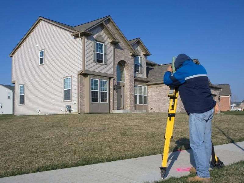 Land surveyor performing a boundary survey to help property owners clarify land lines and ownership records.