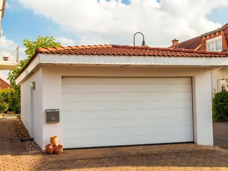 Residential property with a detached garage and paved driveway reflecting years of site improvements and additions.
